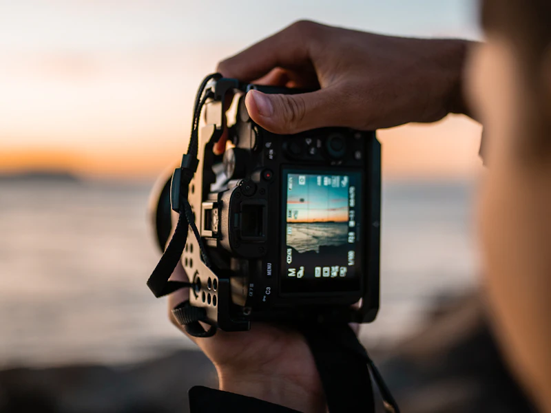 Hands holding a camera at golden hour